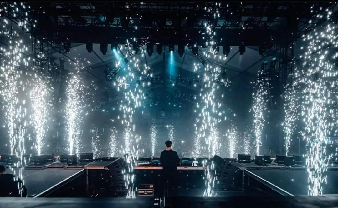 A man standing in front of a stage with lights.